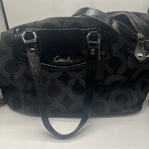 Black purse with shoulder and arm straps. The purse has three inside pocket.